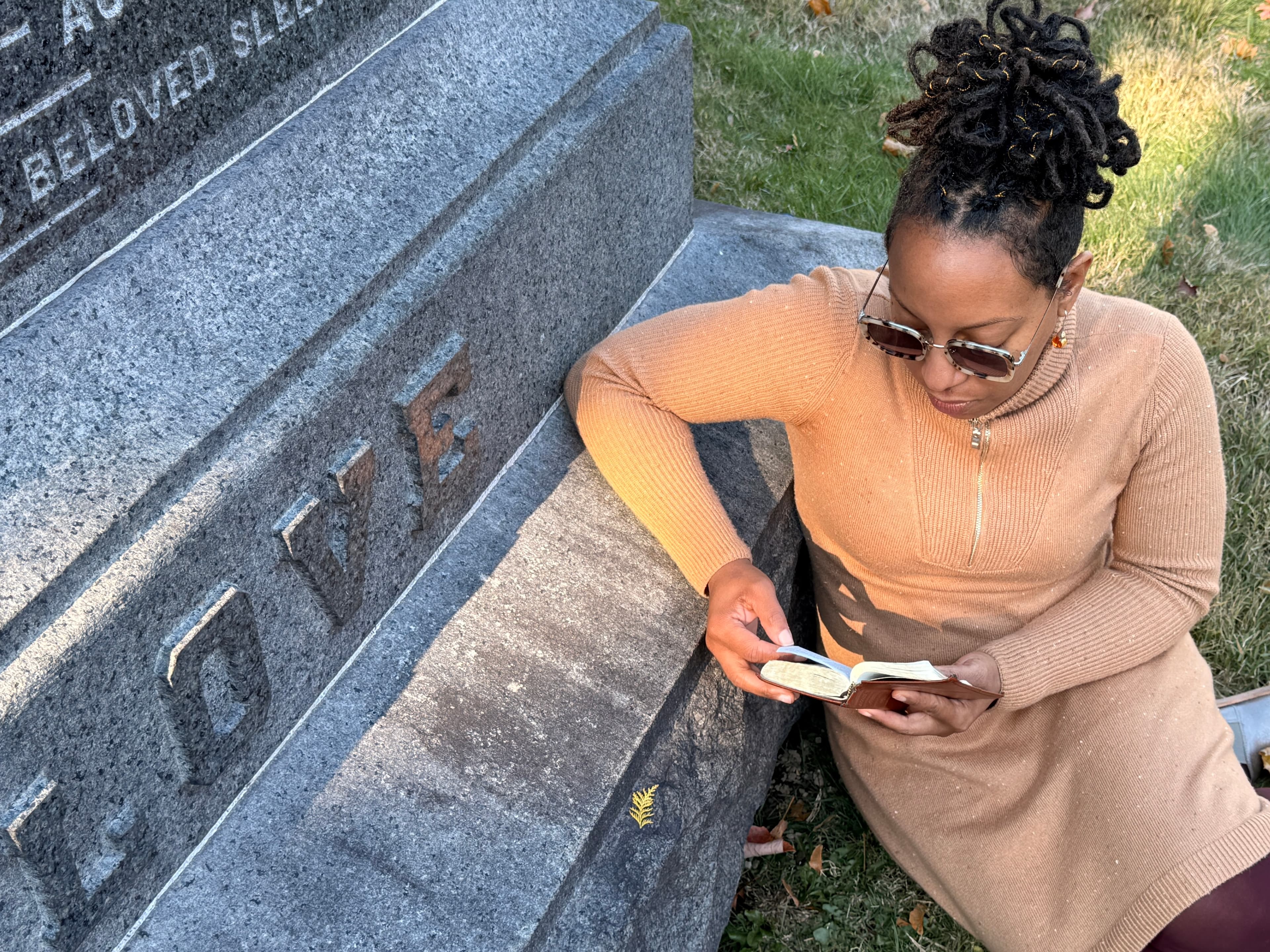 Founder reading beside a gravestone